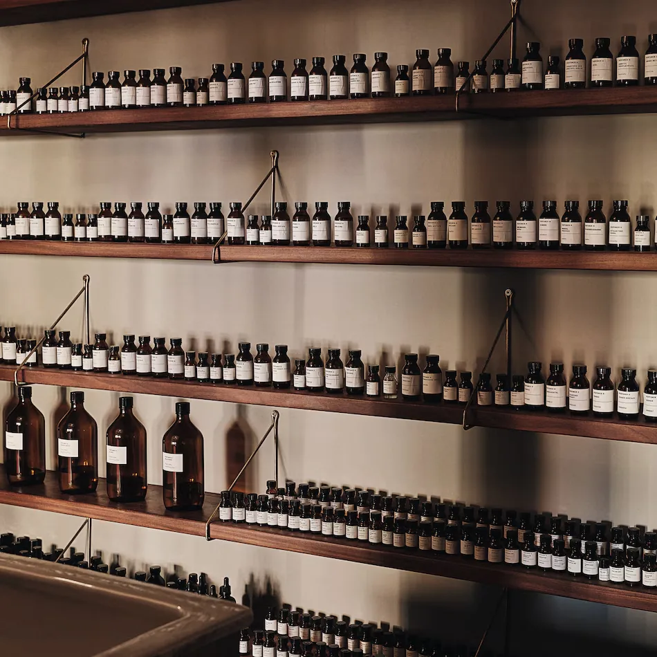 Perfumer H 層架上整齊排列的香氛原料與瓶器
