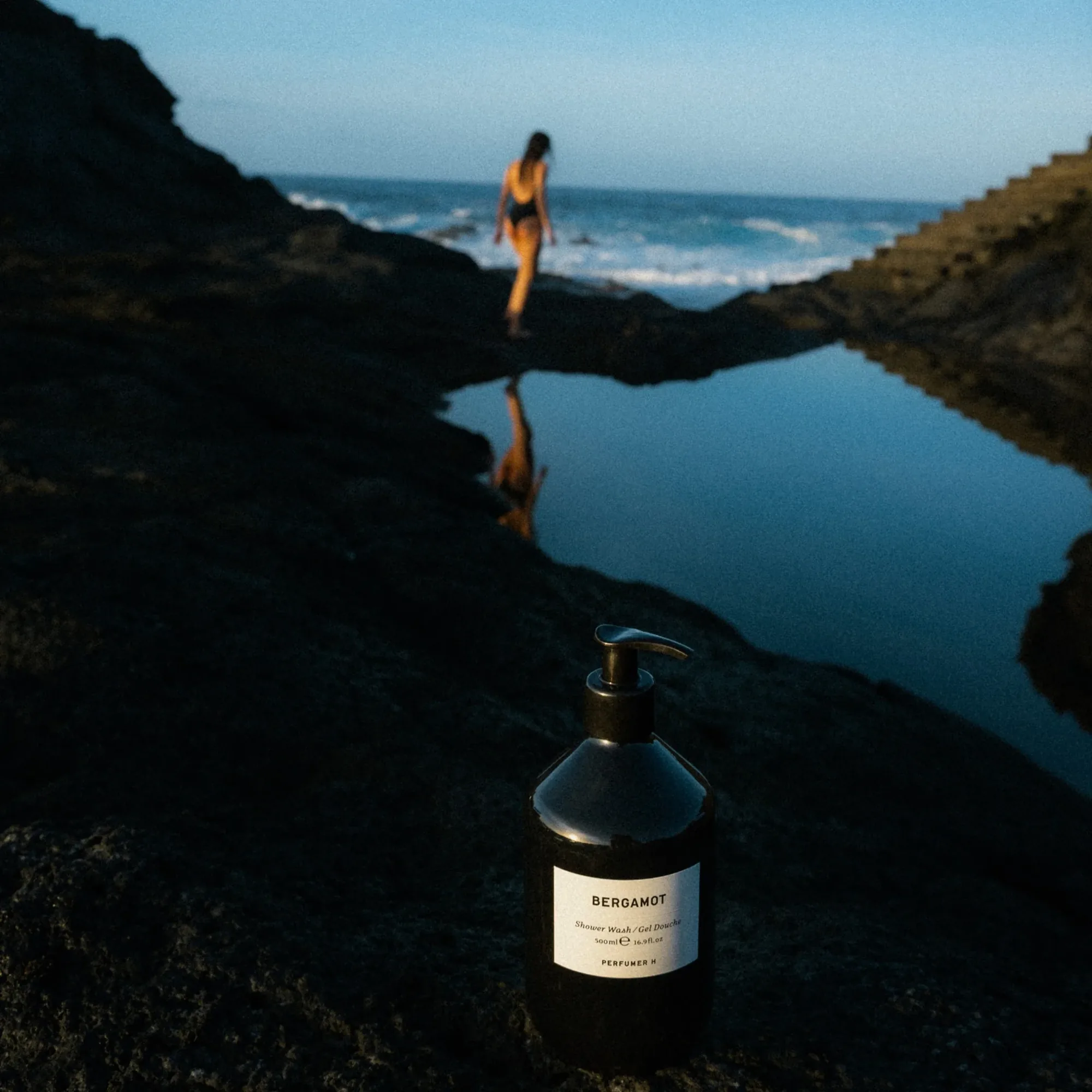 Perfumer H 沐浴產品放在岩石海岸,遠處有人影
