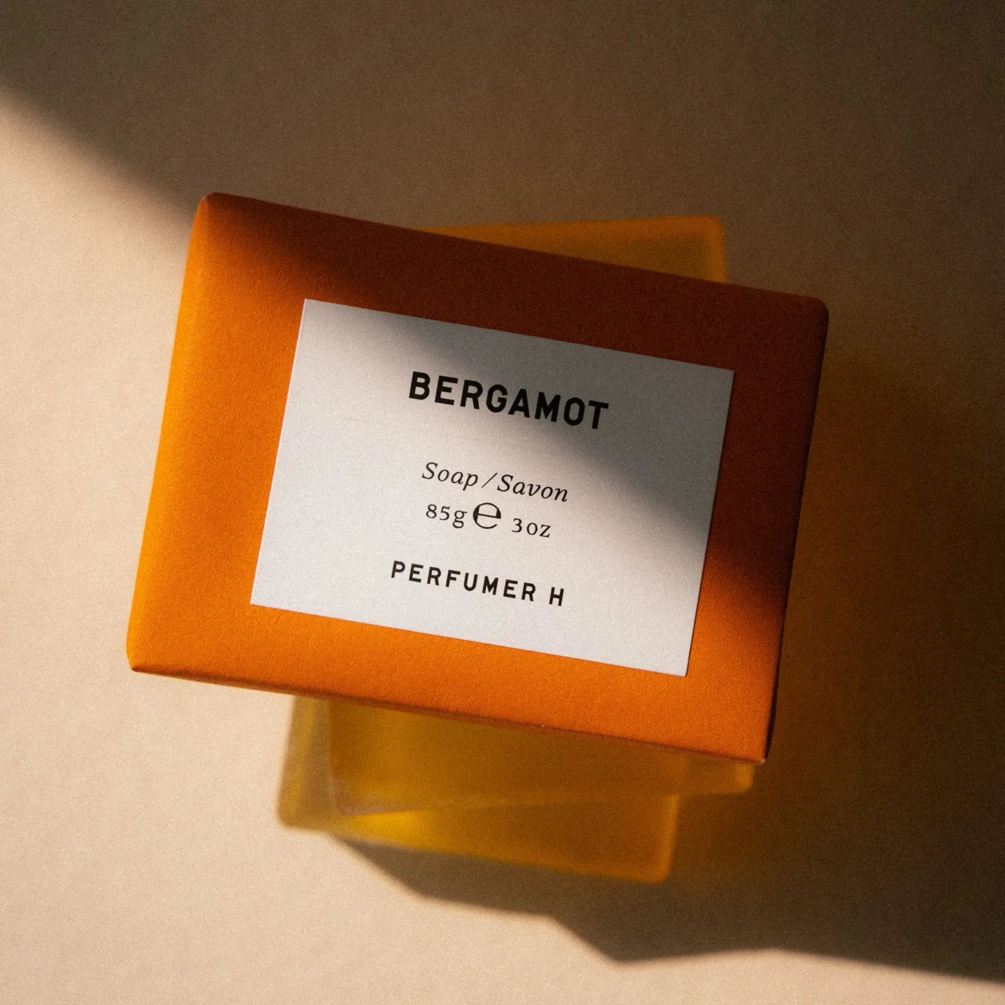 半透明橙色的 Perfumer H Bergamot 香皂,在暖陽下